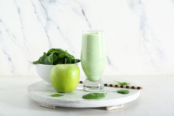 Glass of fresh spinach smoothie with apple on white background