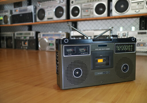 a retro boombox on wooden floor with lots of boomboxes background