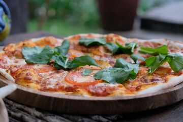 Close up view of pizza margherita with mozarella cheese, basil and tomatoes traditional Italian food.