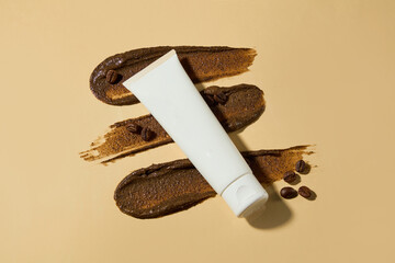 A few streaks of dark brown exfoliating scrub cream highlight an unlabeled white cosmetic tube...
