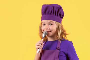 Funny kid chef cook with spoon, studio portrait. Excited chef cook. Child wearing cooker uniform and chef hat preparing food, studio portrait.