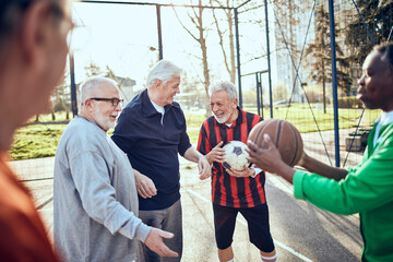 Senior men playing soccer and basketball at a community sports park