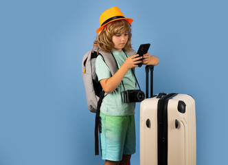 Kids travel. Happy child boy in travel hat with suitcases isolated on studio backgraund. Travel lifestyle and dreams of travel.
