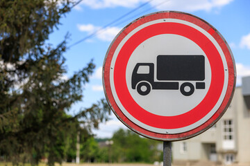 A red and white sign with a truck symbol on it