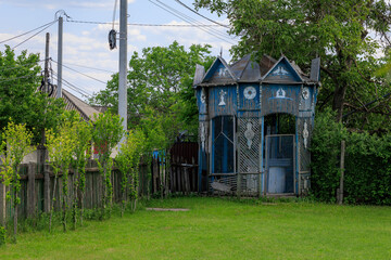 A blue house with a blue gazebo in the yard
