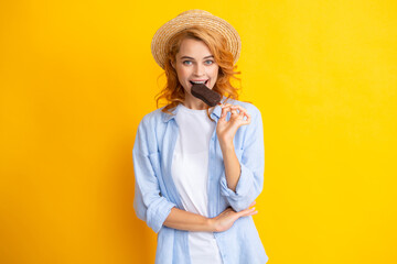 Fashion portrait cool young woman with ice cream over yellow background. Young cheeky hipster girl eating an ice cream to stick.