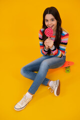 Teenager girl with caramel candies on sticks, sweet sugar addiction. Child with lollipops. Happy teenager, positive and smiling emotions of teen girl.