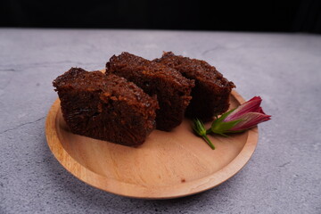 three pieces of caramel chocolate cake in wooden plate