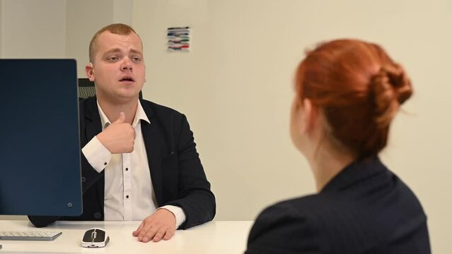 Business partners communicate in sign language. A deaf boss gives a task to a subordinate woman.