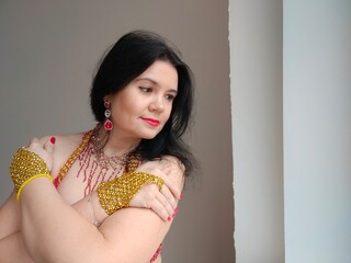 A dancer in a red suit is dancing an oriental dance on a white background. Free space for text....
