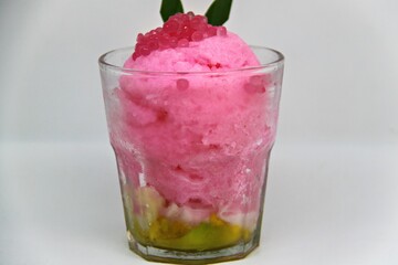 Es doger made from sugared sweet coconut milk based ice in pink syrup, served with red tapioca pearls, avocado, cassava tapai, black glutinous rice, jackfruit, diced bread and condensed milk.