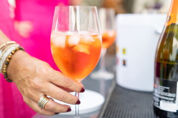 Woman picking a cocktail glass from a table