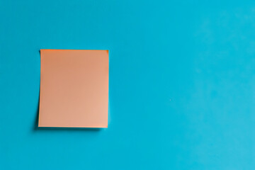 Fototapeta premium A piece of paper is stuck to a blue wall.