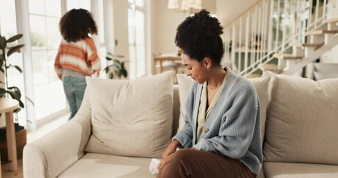 Conversation, mother and girl with sanitary pad on sofa for feminine hygiene, education or menstrual cycle in living room. Advice, parent and young child for health, wellness or gynaecology in home