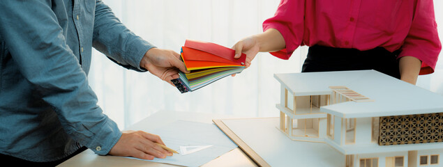 Female architect interior designer send color swatches to project manager for choosing an...