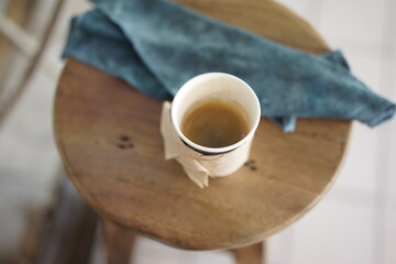Espresso coffee on the wooden stool chair with tea towel.