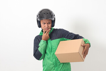 Portrait of Asian online courier driver wearing green jacket and helmet delivering package and box for customer. Isolated image on white background