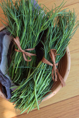 Bunch of fresh Salsola soda in a basket on wooden table. Italian Barba di frate or Agretti or...