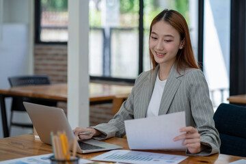 Asian business woman working In office using laptop and tablet, business concept