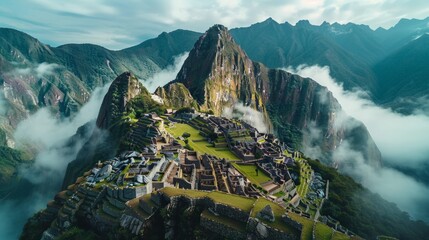 Aerial view of Machu Picchu in Peru, with its ancient Incan ruins perched high in the Andes Mountains and surrounded by lush green forests.     