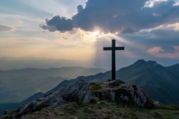 A cross atop a mountain with sun rays, a dramatic sky