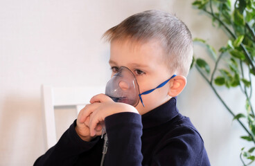 Boy makes inhalation, inhales medicine through mask, treatment of disease. Child has respiratory...