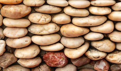 Round stones in the wall as an abstract background. Texture