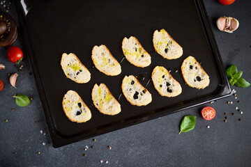 sliced baguette pieces on a baking tray making croutons