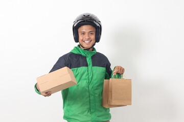Portrait of Asian online courier driver wearing green jacket and helmet giving craft paper shopping...