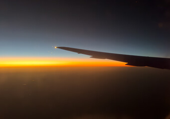 Airplane wing from the window at sunrise in the morning