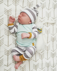 Newborn baby sleeping with striped hat and plush toy