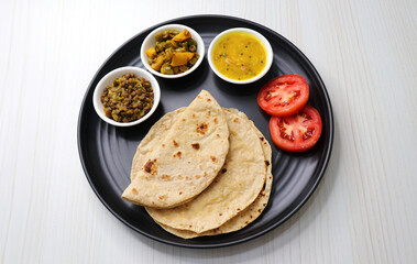 Roti and bhaji. Indian vegetarian Thali or platter includes akhha Masoor sabzi, dal, fansi or beans ki sabji, and chapati. Indian food is served in a plate or thali. Copy Space. healthy Veg Thali.