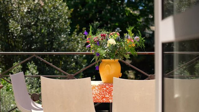 Slow establishing shot of flowers sitting ontop of a table at a villa in Montpellier