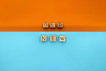 NEWのバックにOLDの英語ブロックが並ぶオレンジと青色に分かれた背景