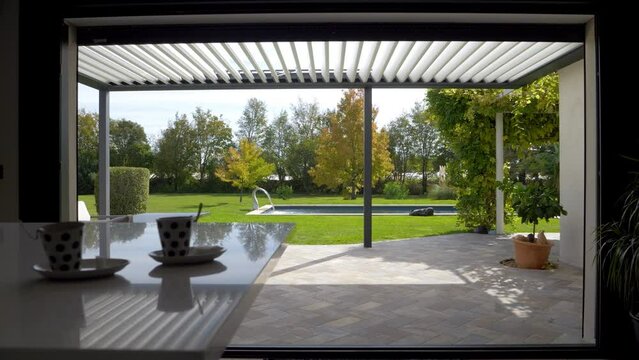 Static shot looking out of a villa with a exterior sunshade and a private pool