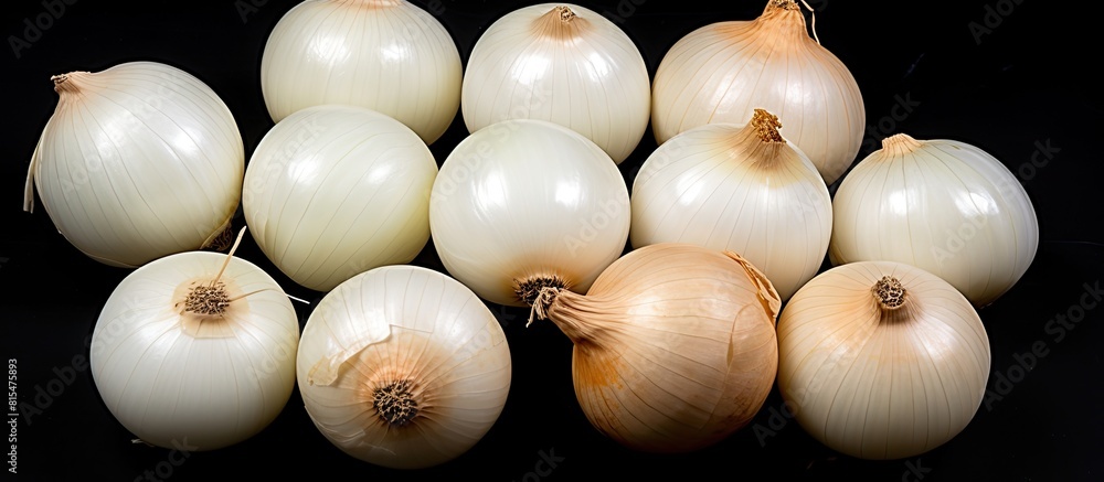 Poster a top view of fresh ripe white onions is displayed on a black background with a free copy space imag