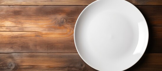 Top view of a white ceramic plate placed on a wooden background and there is ample copy space in the image