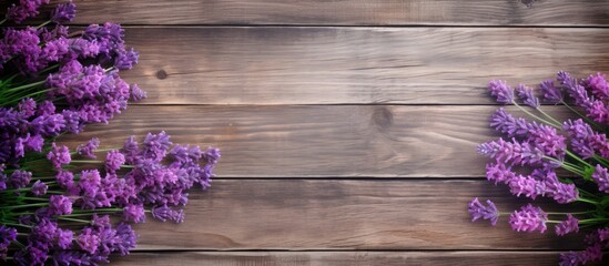 Obraz premium The copy space image features lavender flowers in shades of deep purple or lilac set against a weathered wooden background