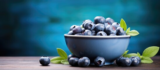 A bowl filled with fresh blueberries creates a vibrant background offering plenty of copy space for your text The image represents the concept of blueberries as antioxidant rich organic superfood for