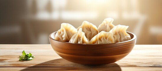 A delicious bowl of dumplings sits on a wooden table with ample copy space for the image