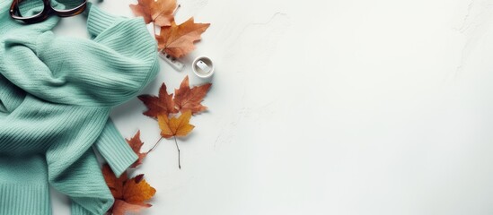 Top view of a cozy autumn flat lay on a white concrete background featuring warm women s clothing in the color of Tiffany including a jacket shoes and scarf with ample copy space for customization