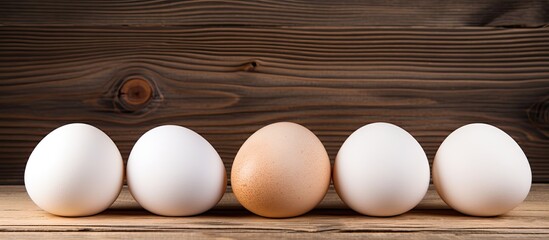 Easter themed wooden background with three white chicken eggs providing a copy space image for text