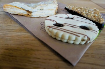 Bio Gebäckteilchen auf braunem Papier über brauner Holztischplatte in Café