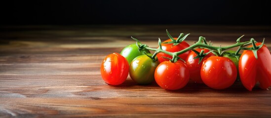 Cherry tomatoes both ripe and unripe displayed on a wooden table with ample copy space for an image