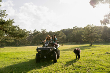 Group of Women and Their Dog Enjoying an ATV Ride in Sunny Forest