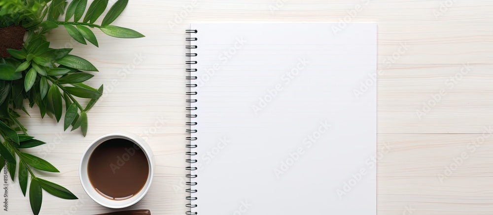 Poster On a white office desk there is a top view of a blank notepad laptop coffee cup and potted plant There is also ample copy space available for your text