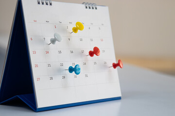 Mark on calendar white paper desk calendar with drawing-pins appointment and business meeting...
