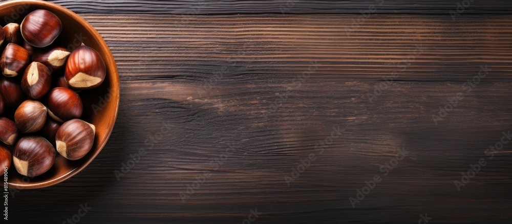 Poster top view of a wooden table with a bowl of roasted sweet chestnuts there is ample space available for