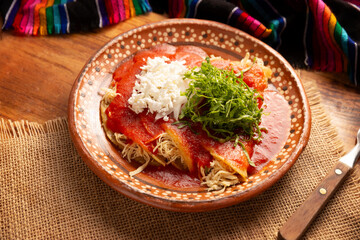 Entomatadas. Also known as Enjitomatadas, a typical dish of Mexican cuisine prepared with corn tortilla, tomato sauce and stuffed with shredded chicken meat. Classic homemade recipe.