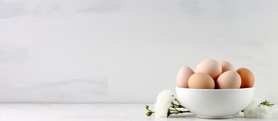 A copy space image featuring a bowl of white eggs placed on a pristine white granite countertop